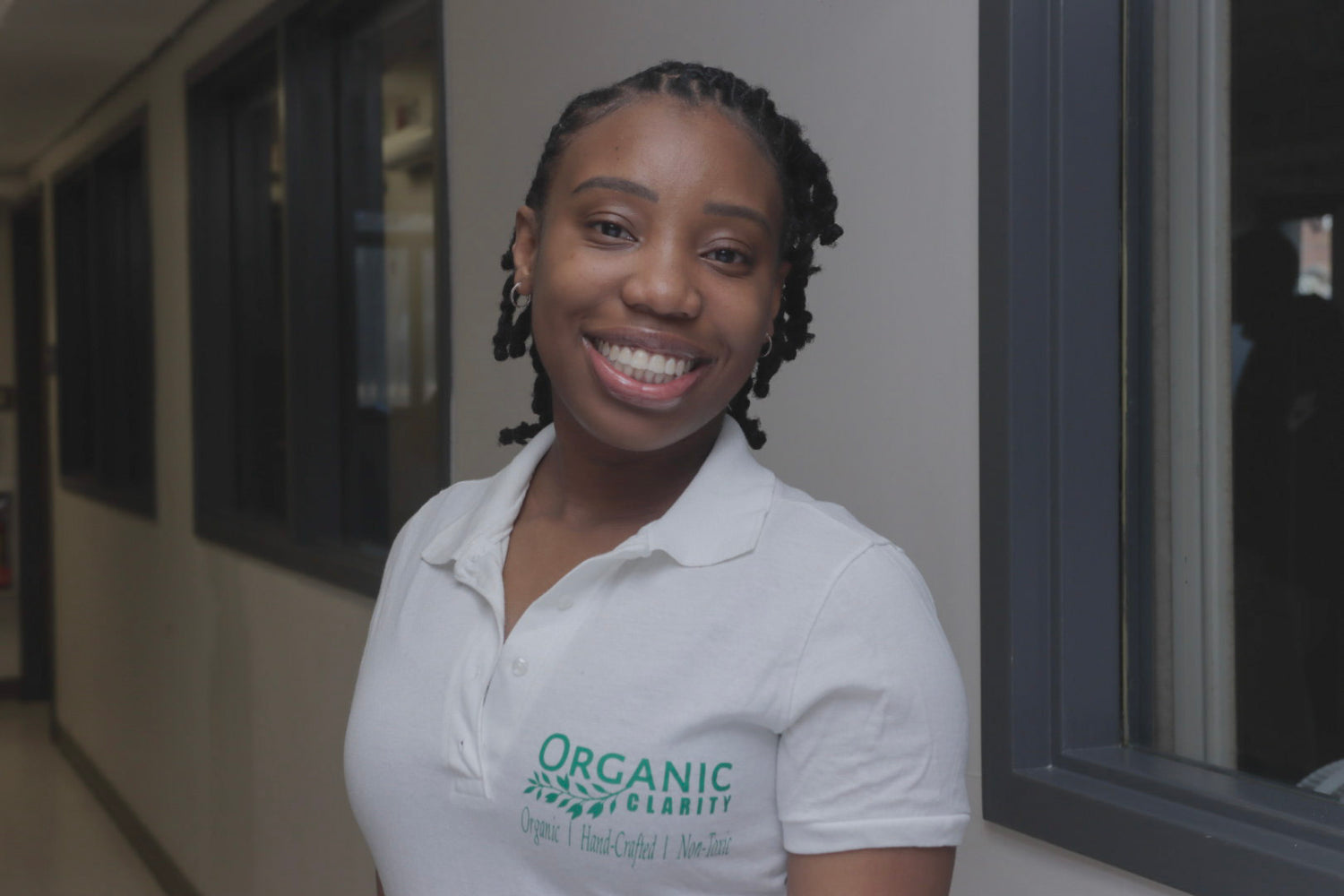 Woman wearing a white shirt with 'Organic Clarity' logo in an indoor setting